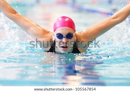 young woman swims the butterfly in the pool
