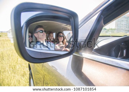 reflection in a side mirror of a family with children in auto