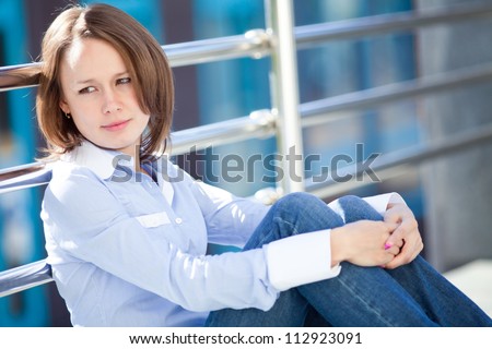 Portrait of mid adult sad woman outside office building background