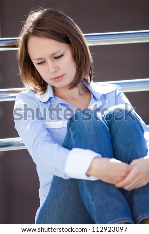 Portrait of mid adult sad woman outside office building background