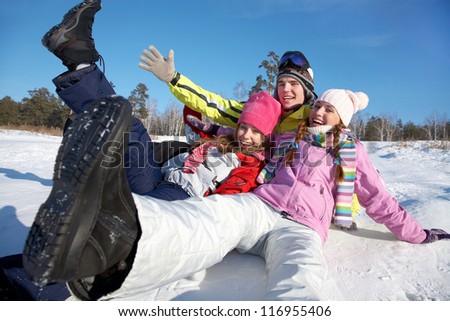 group of young friends tumbles in the snow on a winter vacation