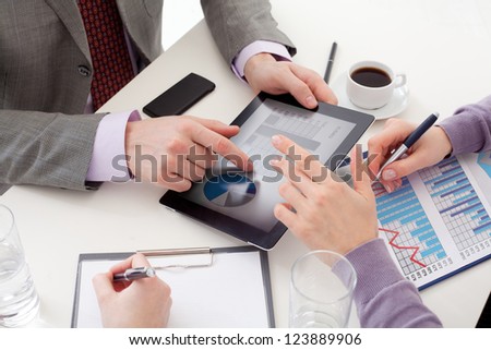 Unrecognizable business colleagues working together and using a digital tablet