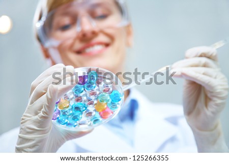 Medical or scientific researcher or doctor using looking at a solution in a laboratory Medical or scientific researcher or doctor using looking at a solution in a laboratory