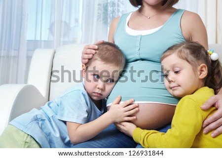 Portrait of happy pregnant woman with her two children together