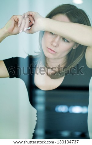 young woman  woman leaned against glass wall in crisis moment