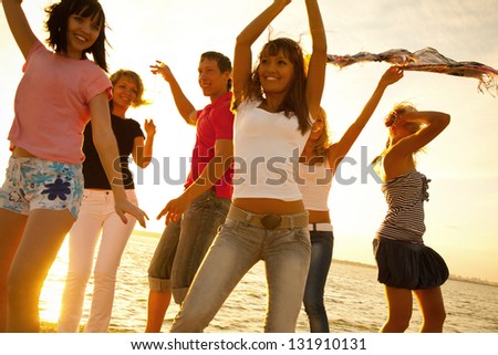 Happy Young Teens Dancing At The Beach On Beautiful Summer Sunset