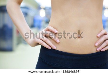 beautiful belly athletic woman at gym. close