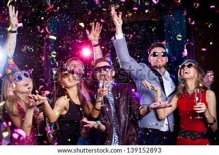 Cheerful Young People Showered With Confetti On A Club Party.