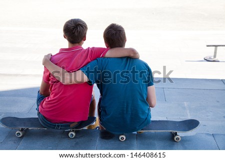 Portrait of back two friends skateboarders on the street
