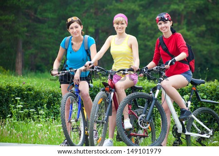 Young pretty women  race on bicycle in green park