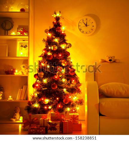 A lighted Christmas tree with presents underneath in living room