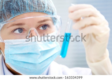 woman scientist holding a test tube with liquid woman scientist holding a test tube with liquid