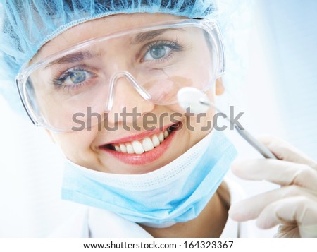 Portrait Of Positive Smiling Dentist With Dental Mirror