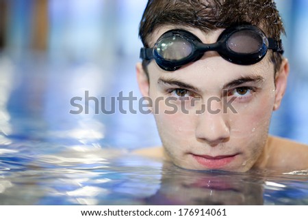 Happy attractive man swimming in blue water in  swimming pool