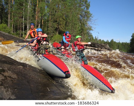 passing of rough river falls by team of people on an inflatable catamaran
