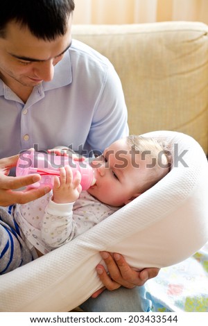 Happy Dad feeding baby bottle