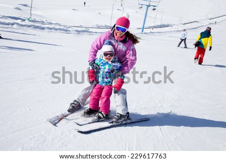 Female instructors teach a child skiing on winter resort