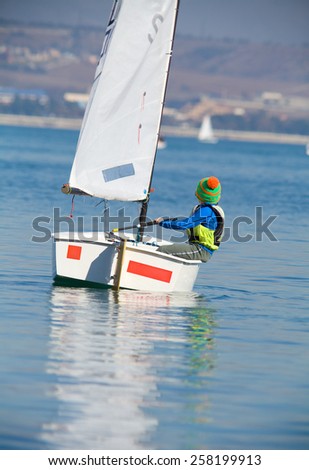 little boy on a small yacht sail