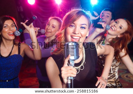 Young girl singing into  microphone at  party