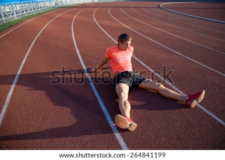 young athlete sits on the track stadium after jogging