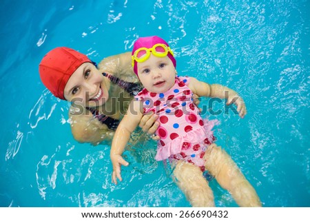 One year  baby girl at his first swimming lesson with mother