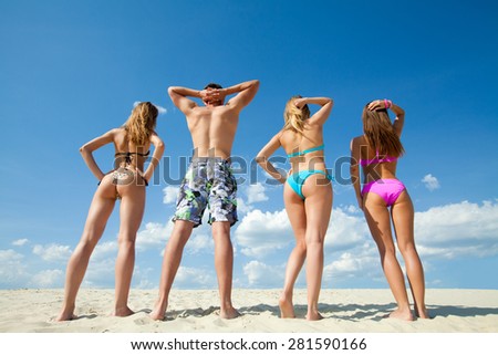 Young people are having good time on the beach. Back view.  unrecognizable