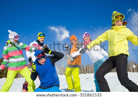 group of friends have a snowball fight