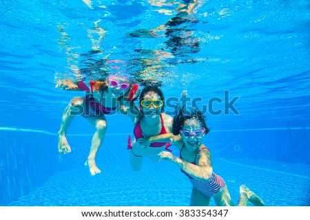 mother with two little girls played under water in the pool