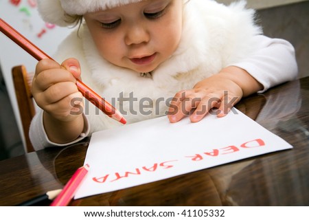 The small child writes the letter to Santa