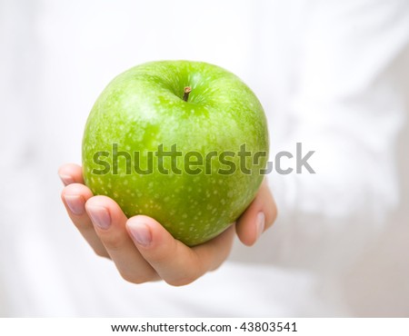 The big green apple in beautiful female hands