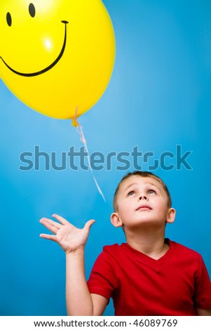 Little boy releases a yellow balloon
