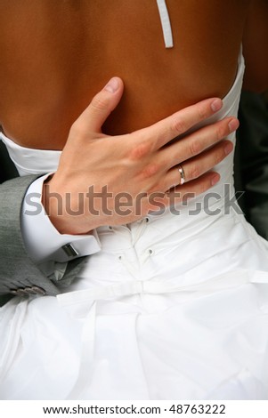 The hand of the groom gently embraces the bride\'s waist
