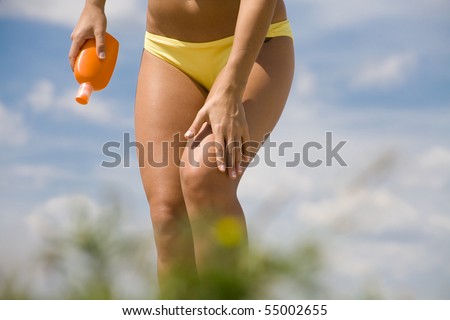 stock photo beautiful tanned woman in bikini body rubs suntan lotion on 