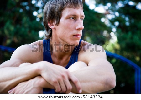 beautiful portrait of the young athlete sitting on the playground