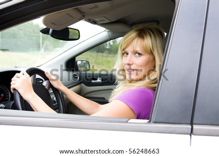 Portrait of young beautiful woman with fair hair sitting in the car