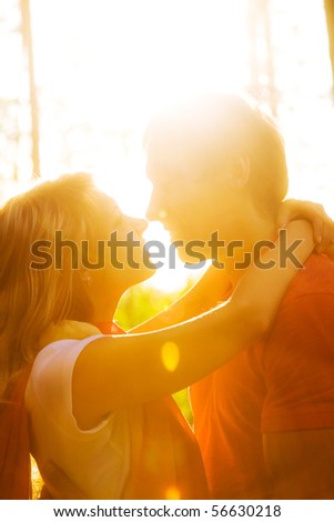 stock photo : Young beautiful pair of lovers kissing at sunset