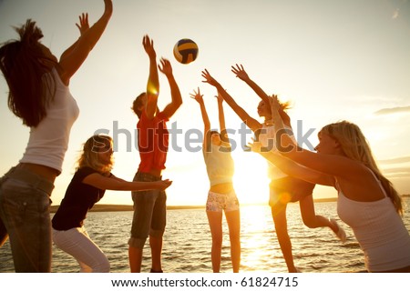 group of young people playing volleyball on the beach group of young people playing volleyball on the beach