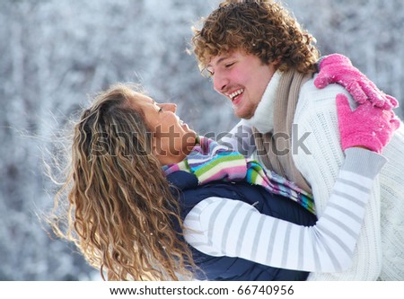 young playful couple has a fun winter time in a snow park