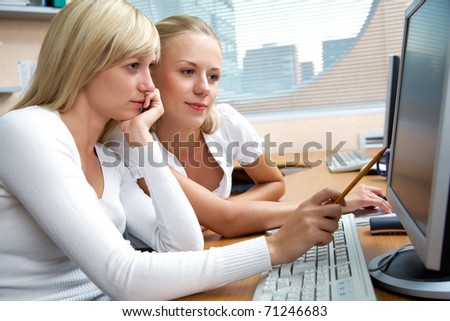 Portrait of beautiful young women working together in the office of the computers