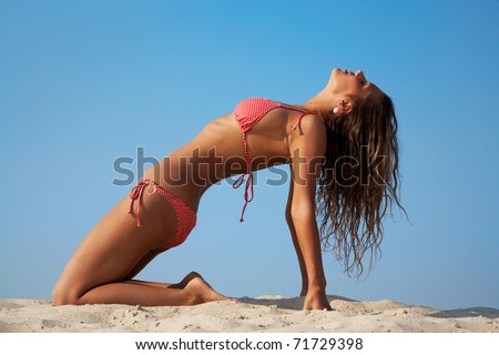 stock photo Mature sexy woman practicing yoga by the beach