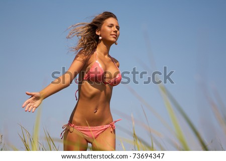 stock photo Tanned beautiful girl jogging on the green meadow