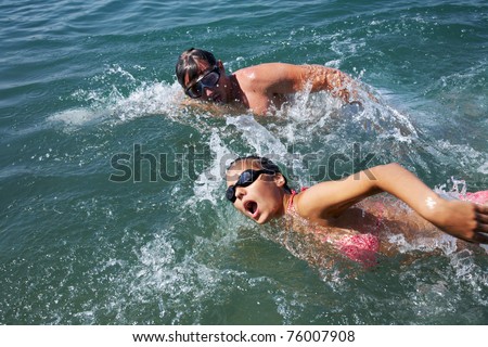 Healthy lifestyle: man and woman are swimming together in open water