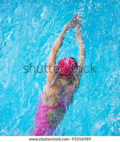 Female swimmer in pink swimwear in pool