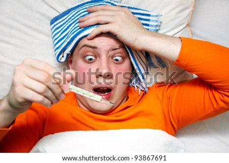Portrait of a sick man lying in bed with fever