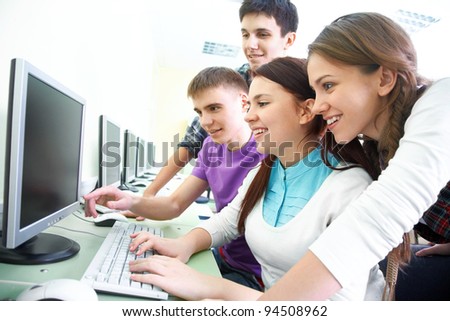 group of young students studying in the classroom with computer