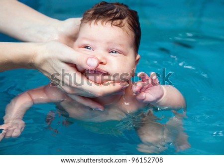 two month old baby girl at his first swimming lesson
