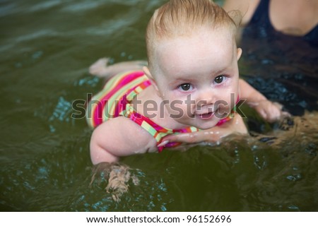 Six month old baby girl at his first swimming lesson