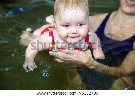Six month old baby girl at his first swimming lesson