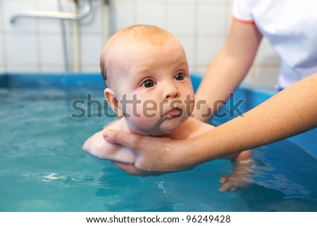 Six month old baby boy at his first swimming lesson