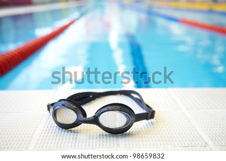 Image of swimming pool and goggles. Nobody